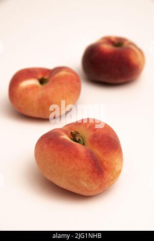 Donut Pfirsiche vor einem gelblich weißen Hintergrund Stockfoto