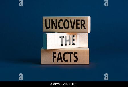 Entdecken Sie das Facts-Symbol. Concept Words enthüllen die Fakten auf Holzblöcken auf einem schönen grauen table grey Hintergrund. Und die Fakten aufdecken c Stockfoto