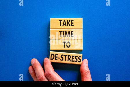 Nehmen Sie sich Zeit, um das Symbol zu entspannungsfrei zu machen. Konzeptwörter nehmen sich Zeit, um auf Holzklötzen Stress abzubauen. Schöne blaue Tabelle blauen Hintergrund. Psychologisches Geschäft und Stockfoto