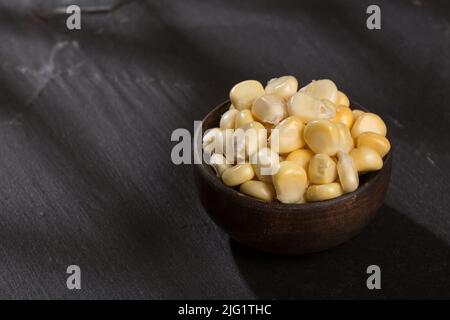 Zea mays - Holzschale mit frischen Maiskörnern. Stockfoto