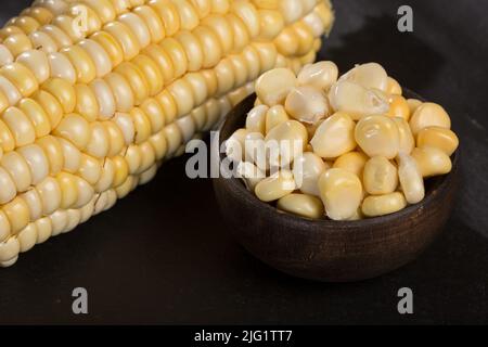 Zea mays - Holzschale mit frischen Maiskörnern. Stockfoto