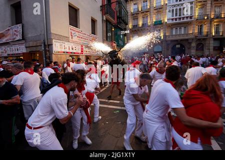 Pamplona, Spanien. 06.. Juli 2022. Am 8. Juli 2022 laufen Menschen vor einem Feuerbullen beim San Fermin Festival in Pamplona, Nordspanien. Nachtschwärmer aus aller Welt strömen jedes Jahr nach Pamplona, um am achttägigen Lauf der Bullen teilzunehmen (Foto: Ruben Albarran / PRESSINPHOTO) Quelle: PRESSINPHOTO SPORTS AGENCY/Alamy Live News Stockfoto