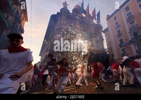 Pamplona, Spanien. 06.. Juli 2022. Am 8. Juli 2022 laufen Menschen vor einem Feuerbullen beim San Fermin Festival in Pamplona, Nordspanien. Nachtschwärmer aus aller Welt strömen jedes Jahr nach Pamplona, um am achttägigen Lauf der Bullen teilzunehmen (Foto: Ruben Albarran / PRESSINPHOTO) Quelle: PRESSINPHOTO SPORTS AGENCY/Alamy Live News Stockfoto