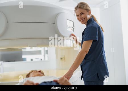 Der Radiologe steuert die MRT- oder CT- oder PET-Scans mit dem Patienten, der sich einer Untersuchung unterziehen muss, und einer Kamera, die sich im Blick befindet Stockfoto