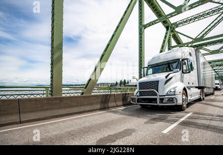 Weiße Motorhaube Industrietauglicher großer Sattelschlepper mit Schlafraum für LKW-Fahrer und mit trockenem Transporter, der Ladung transportiert, die auf t läuft Stockfoto