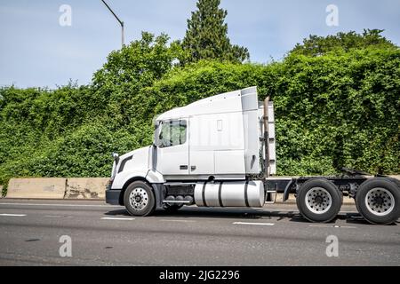 Weiße Motorhaube Industrietaugliches großes Rig-Semi-Truck mit LKW-Fahrerhaus Schlafraum und mit geschmiertem fünftem Rad fahren auf der breiten Autobahn r Stockfoto