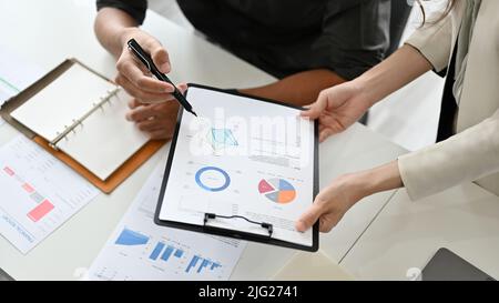 Draufsicht, Eine Geschäftsfrau oder Managerin, die analysiert und die Finanzdaten des Berichts mit ihren Kollegen im Büro überprüft. Zugeschnittenes Bild Stockfoto