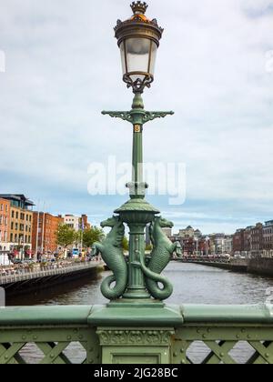 Zwei gusseiserne Seepferde aus dem 19.. Jahrhundert (Hippocampi) schmücken diesen Laternenpfosten auf der Grattan Bridge über den Fluss Liffey in Dublin, Irland. Stockfoto