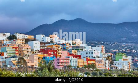 Farbenfrohe Gebäude in Santa Cruz de La Palma mit Kopierfläche. Schöne Stadtlandschaft mit hellen Farben Berge und bewölkten Wolken. Ein lebhafter Urlaub Stockfoto