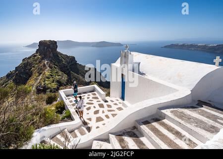 Traditionelle weiße griechische Kirche mit einem atemberaubenden Blick über den Skaros-Felsen in Santorini, Griechenland Stockfoto