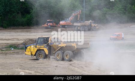 Salzgitter, Deutschland. 18.. Mai 2022. Baufahrzeuge fahren über eine große Baustelle im VW-Werk Salzgitter. Volkswagen baut am Standort Salzgitter eine Batteriezellenfabrik für die geplante Großproduktion der konzerneigenen Batteriezellen. Im Forschungs- und Entwicklungszentrum werden bereits neue Batteriesysteme für Elektroautos entwickelt. Quelle: Julian Stratenschulte/dpa/Alamy Live News Stockfoto