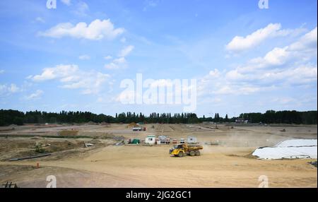 Salzgitter, Deutschland. 18.. Mai 2022. Baufahrzeuge fahren über eine große Baustelle im VW-Werk Salzgitter. Volkswagen baut am Standort Salzgitter eine Batteriezellenfabrik für die geplante Großproduktion der konzerneigenen Batteriezellen. Im Forschungs- und Entwicklungszentrum werden bereits neue Batteriesysteme für Elektroautos entwickelt. Quelle: Julian Stratenschulte/dpa/Alamy Live News Stockfoto