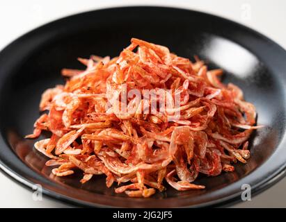 Getrocknete Sakura-Garnelen auf einem Teller auf weißem Hintergrund. Bild von japanischem Essen. Stockfoto