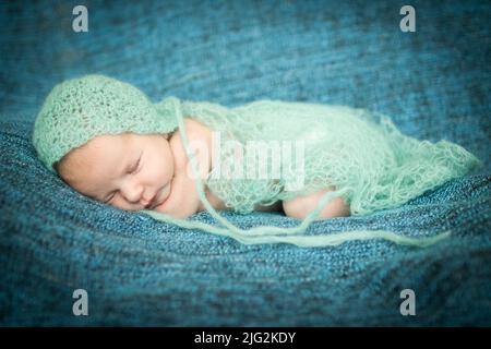 Neugeborenes Baby schläft süß auf einem blauen Hintergrund Stockfoto