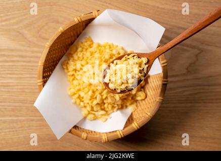 Tenkasu serviert in einem Sieb auf einem hölzernen Hintergrund mit einem Holzlöffel. Bild von japanischem Essen. Blick von oben. Stockfoto