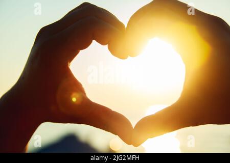 Das Herz der Hände gegen den Himmel. Stockfoto