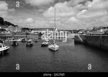 Eine zu Besuch einende Yacht liegt im Innenhafen von Porthleven, Cornwall Stockfoto