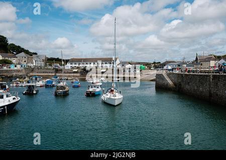 Eine zu Besuch einende Yacht liegt im Innenhafen von Porthleven, Cornwall Stockfoto