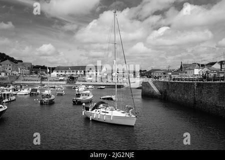 Eine zu Besuch einende Yacht liegt im Innenhafen von Porthleven, Cornwall Stockfoto