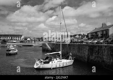 Eine zu Besuch einende Yacht liegt im Innenhafen von Porthleven, Cornwall Stockfoto