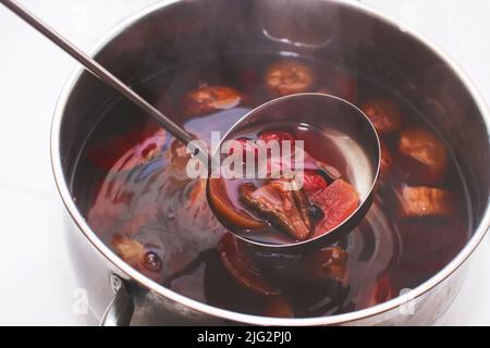 Schöpfkelle mit Kompott über einer Pfanne Stockfoto