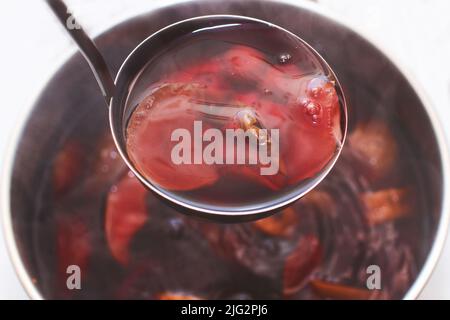 Schöpfkelle mit Kompott über einer Pfanne Stockfoto