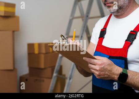 Mann mittleren Alters in Uniform Notizen auf Zwischenablage Stockfoto