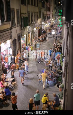 Geschäftige Nachtszene entlang der Via Faenza in Florenz, Italien Stockfoto