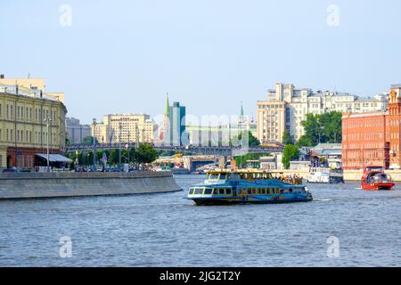 Moskau. Russland. 26. Juni 2021. An einem sonnigen Sommertag segeln Vergnügungsboote entlang des Flusses Moskau vor dem Hintergrund des Moskauer Kremls. Die Arbeit der Lustflußflotte im Sommer in Moskau Stockfoto