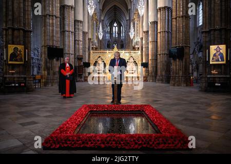 Fileposit vom 07/05/20 des Dekans von Westminster, Reverend Dr. David Hoyle (links), der im Vorfeld der gedenkfeiern zum 75.. Jahrestag des VE Day Premierminister Boris Johnson anschaut, wie er eine Kerze am Grab des unbekannten Kriegers in der Westminster Abbey in London anzündet. Boris Johnson wird seinen Rücktritt heute, wahrscheinlich vor Mittag, öffentlich bekannt geben, berichtet die BBC. Ausgabedatum: Donnerstag, 7. Juli 2022. Stockfoto