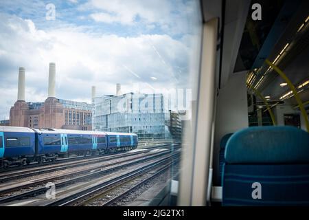 London - 2022. Juni: Blick vom Inneren des Zuges auf das Battersea Power Station und den Zug im Südwesten Londons Stockfoto