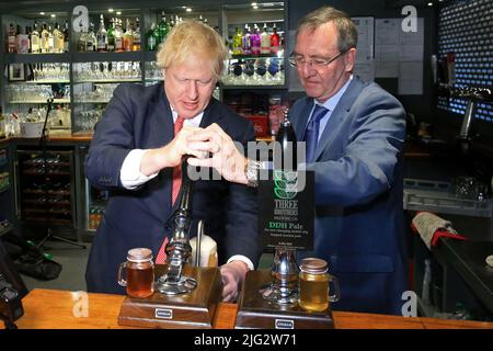 Fileblickfoto vom 14/12/19 von Premierminister Boris Johnson (links), der mit dem neu gewählten Abgeordneten der konservativen Partei für Sedgefield, Paul Howell, während eines Besuches im Sedgefield Cricket Club in der Grafschaft Durham ein Bier zog. Boris Johnson wird seinen Rücktritt heute, wahrscheinlich vor Mittag, öffentlich bekannt geben, berichtet die BBC. Ausgabedatum: Donnerstag, 7. Juli 2022. Stockfoto