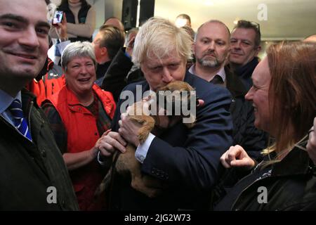 Datei-Foto vom 14/12/19 von Premierminister Boris Johnson, der während eines Besuchs im Sedgefield Cricket Club in der Grafschaft Durham einen Hund eines Unterstützers küsst. Boris Johnson wird seinen Rücktritt heute, wahrscheinlich vor Mittag, öffentlich bekannt geben, berichtet die BBC. Ausgabedatum: Donnerstag, 7. Juli 2022. Stockfoto