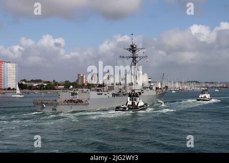 Die Schlepper, DIE NACHSICHTIG und GROSSZÜGIG sind, begleiten den von der US Navy geführten Raketenjäger USS AUF SCHWERE WEISE zu einem Liegeplatz im Marinestützpunkt Stockfoto