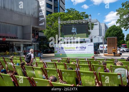 London - 2022. Juni: Liegestühle draußen und Wimbledon-Tennis auf der Leinwand im Rahmen des Sommerfestivals in Hammersmith, West-London Stockfoto