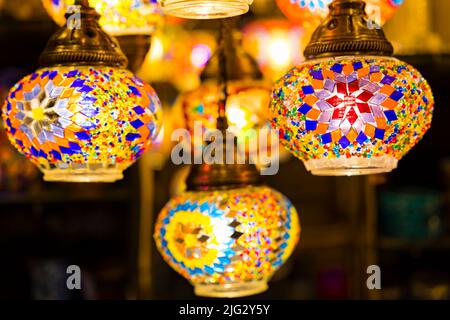 Traditionelle handgemachte mehrfarbige türkische, marokkanische, arabische Lampen hängen mit schönen unscharfen Hintergrund. Mosaikstil und Laterne aus farbigem Glas. Stockfoto