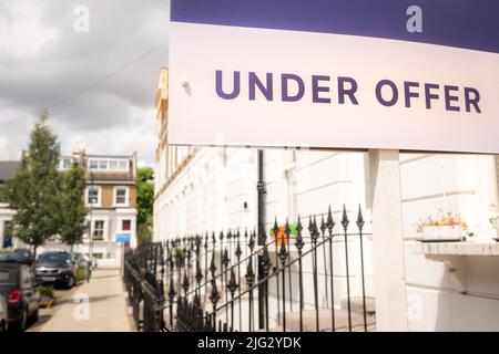 Immobilienmakler "under Offer" Zeichen auf der Straße der britischen Vorstadt Häuser Stockfoto