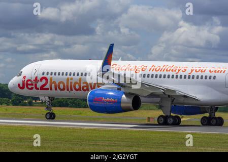 Jet2 Feiertage Boeing 757-23N REG G-LSAK am Flughafen Manchester mit dem Hauptterminal im Hintergrund. Stockfoto