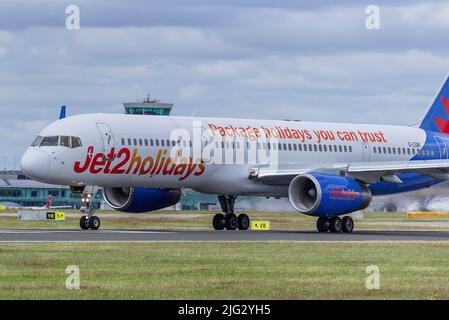 Jet2 Feiertage Boeing 757-23N REG G-LSAK am Flughafen Manchester mit dem Hauptterminal im Hintergrund. Stockfoto