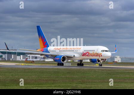 Jet2 Feiertage Boeing 757-23N REG G-LSAK am Flughafen Manchester mit dem Hauptterminal im Hintergrund. Stockfoto