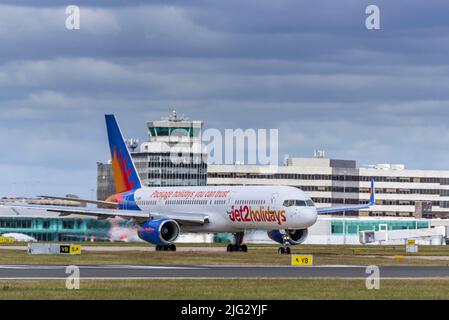 Jet2 Feiertage Boeing 757-23N REG G-LSAK am Flughafen Manchester mit dem Hauptterminal im Hintergrund. Stockfoto