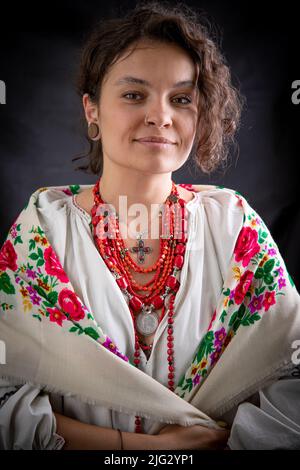 Eine wunderschöne ukrainische Frau in traditioneller Kleidung auf dunklem Hintergrund Stockfoto