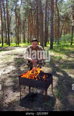 Roher Grill auf Metallspieß im Wald. Stockfoto