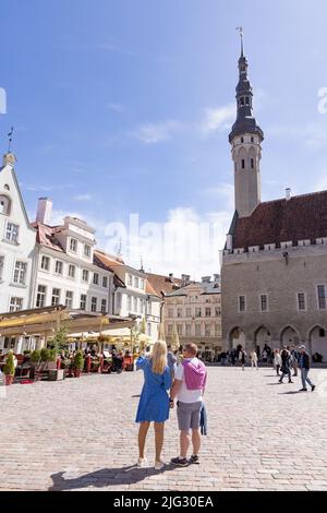 Tallinns Touristen; ein Paar auf dem Altstädter Ring vor dem Rathaus von Tallinn in den Ferien, der Rathausplatz von Tallinn, Tallinn Estland Europa Stockfoto