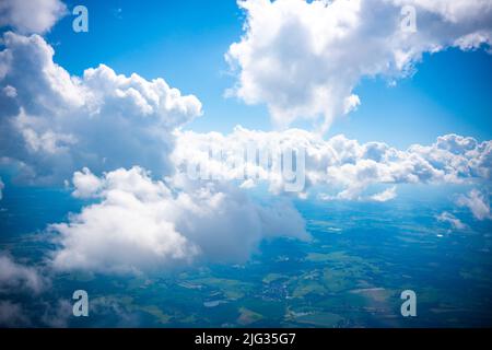 Luftaufnahme Szene der ländlichen Ort, die unter weißen flauschigen Wolken und blauen hellen Himmel Hintergrund versteckt. Stockfoto