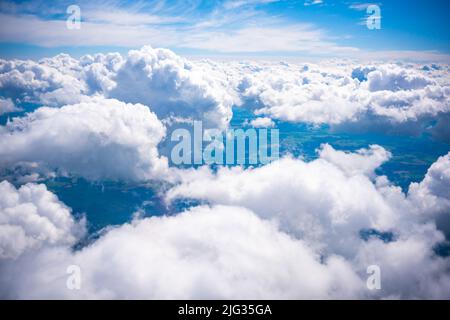 Luftaufnahme Szene der ländlichen Ort, die unter weißen flauschigen Wolken und blauen hellen Himmel Hintergrund versteckt. Stockfoto