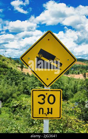 Straßenschild in Khao Kho, Thailand, warnt LKW-Fahrer vor einem steilen Abstieg, Höchstgeschwindigkeit 30 km pro Stunde. Stockfoto