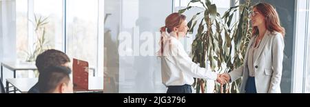 Zwei selbstbewusste Geschäftsfrau zittern vor dem Treffen im modernen Büro Stockfoto