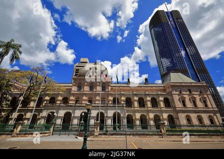 042 Parliament House, das von einem hohen modernen Wolkenkratzer mit Blick auf den Botanischen Garten der Stadt unterstützt wird. Brisbane-Australien. Stockfoto