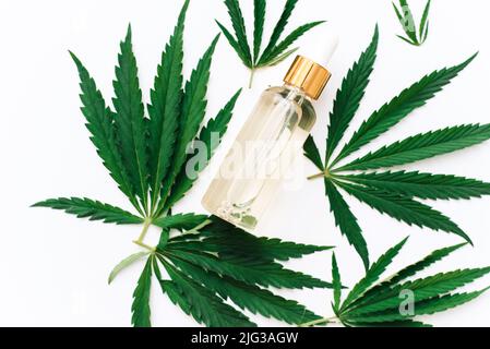 Hanf CBD-Öl in einer Flasche auf weißem Hintergrund mit Hanfblättern, Biomedizin und Ökologie, Hanfgras, Medizin, cbd-Öl aus einem medizinischen Extrakt Stockfoto